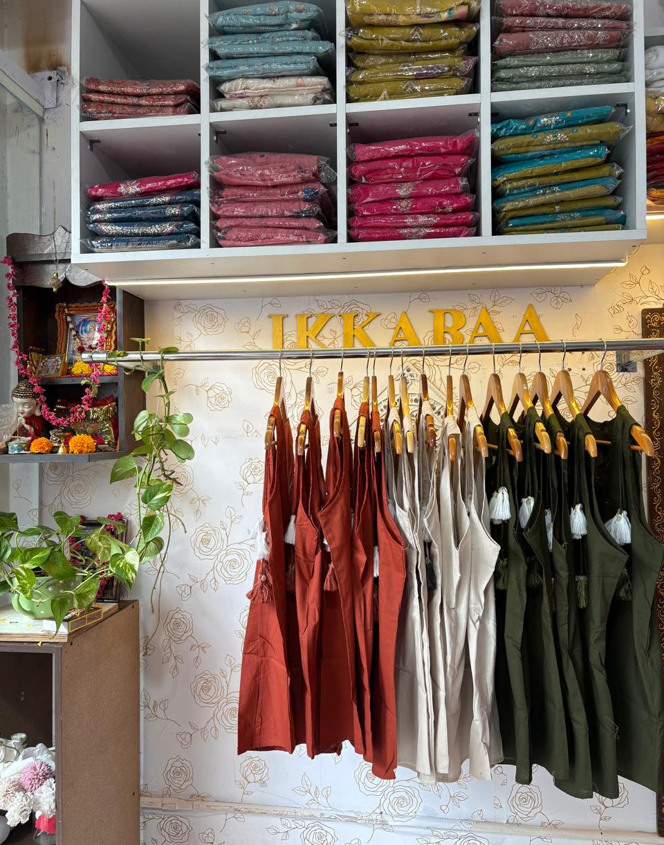 Clothing store interior with hanging shirts and a shelf displaying folded garments.